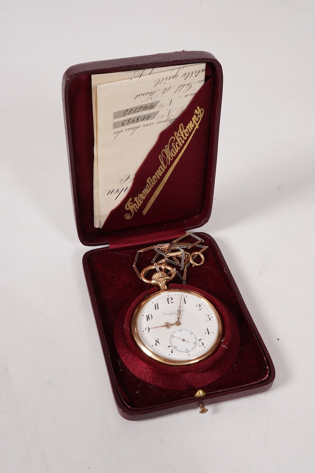 An early 20th century International Watch Company engine turned 14k yellow metal open faced keyless lever pocket watch, together with a Viennese? two colour yellow metal albert, maker's mark, LE